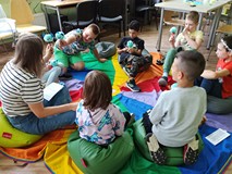 Dzieci rozmawiają z prowadzącą siedząc w kole