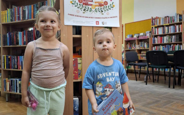 Chłopiec stoi z siostrą i pokazuje pakiet z akcji 