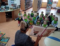 Na zdjęciu Gosia czyta przedszkolakom książkę o dinozaurach