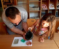 Na zdjęciu pan Tomek pomaga uczestniczce zajęć przy tworzeniu mydełka