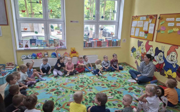 Dzieci siedzą na dywanie i rozmwiają o szczęściu
