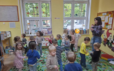 Bibliotekarka razem z dziećmi podczas zabawy integracyjnej