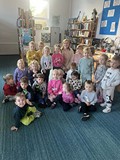 bibliotekarka pozuje do zdjęcia z przedszkolakami