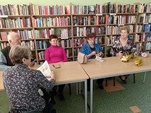 Seniorzy rozmawiają i tworzą kwiaty