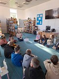 bibliotekarka czyta opowiadanie dzeciom