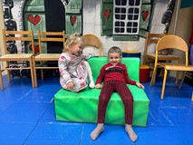 Dzieci siedzą na pufie