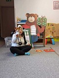 bibliotekarka pokazuje dzieciom misia uszatka