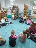 bibliotekarka czyta opowiadanie dzeciom