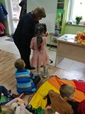 Dziewczynka z zasłoniętymi oczami rysuje misia. Grupa Misiów 25. listopada