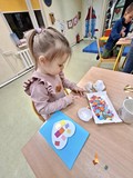 Dziewcynka wykonuje pracę plastyczną