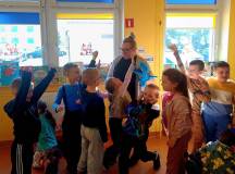 Przedszkolaki podczas zabawy raz-dwa-trzy T-rex patrzy