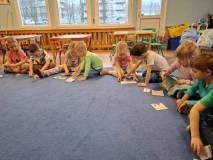 Dzieci siedzą na dywanie i układają puzzle