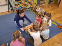 Bibliotekarka pokazuję karton z kolorowymi kartkami