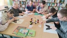 Uczestnicy wykonują pracę plastyczną Motyle