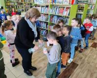 Bibliotekarka częstuje dzieci wodą