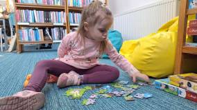 dziewczynka układa puzzle
