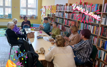 Panie siedzą przy stole, robią na drutach, rozmawiają