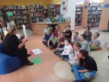 Na zdjęciu przedszkolaki dzielą dinozaury na roślinożerne i mięsożerne