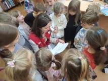 Bibliotekarka czyta dzieciom kolejną wiadomość