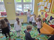 Dzieci szukają zagadek między bibliotecznymi regałami
