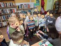 Bibliotekarka czyta dzieciom zagadkę
