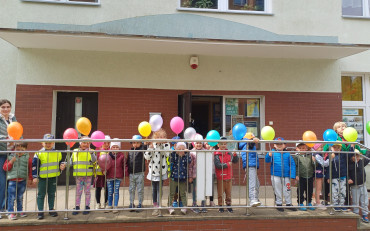 Na zdjęciu grupa PSZCZÓŁEK pozuje z balonami przed naszą biblioteką