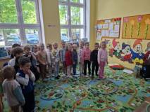 Dzieci stoją jeden za drugim na kolorowym dywanie
