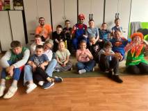 Superbohaterowie pozują do wspólnego zdjęcia z dziećmi