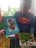 Superman pozuje do zdjęcia z prezentem