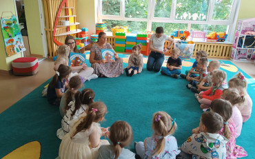 Bibliotekarki pokazują książkę dzieciom