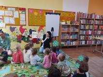 Bibliotekarka czyta dzieciom bajkę o pszczółkach.