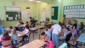 Uczniowie tworzą plakaty w grupach