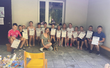 Dzieci pozują do zdjęcia z Martą Maj i psem Preclem