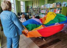 Pani Ania z dziećmi podczas zabawy chustą animacyjną