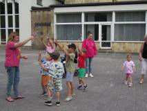 Prowadząca Agnieszka puszcza bańki z dziećmi.