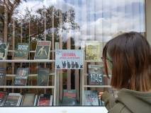 Studentka Maja przed witryną okienną  Filii nr 5, ogladająca wystawę książek.