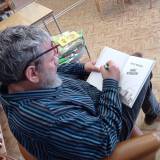 Pan Paweł Wakuła podpisuje książkę w bibliotece