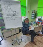 Paweł Wakuła wpisuje dedykację do książki. Obok ilustracja przedstawiająca Mikołaja Kopernika