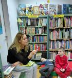 Bibliotekarka czyta dzieciom zadania