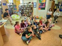 Wiola czyta Ekotropkom książkę Superbohaterzy są wśród nas, autorstwa Santi Beascoa