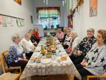 Panie z klubu gier planszowych siedzą wspólnie przy wigilijnym stole