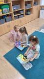 dzieci oglądają książki przyniesione z biblioteki