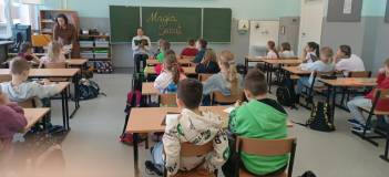 Dzieci słuchają jak bliotekarka czyta książkę
