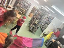 Panie bibliotekarki trzymają tunel animacyjny przez, który przechodzą do sali chętne dzieci.