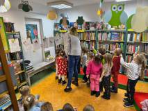 Bibliotekarka z dziećmi ustawiają bałwanki z wiersza Wandy Chotomskiej pt. 