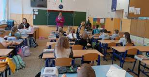 Uczniowie rozmawiają o książce z bibliotekarką.