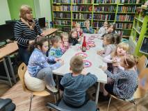 Grupa przy stole świętuje urodziny Kubusia