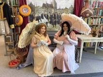 Dwie uczestniczki pozują w strojach z epoki w czasie Oświeconej Nocy w Bibliotece