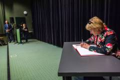 Zasłużona bibliotekarka dokonuje wpisu do Księgi zasłużonych bibliotekarzy regionu koszalińskiego w 