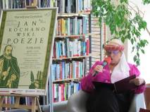 Przebrana kobieta czyta poezje Jana Kochanowskiego w czasie Narodowego Czytania w bibliotece